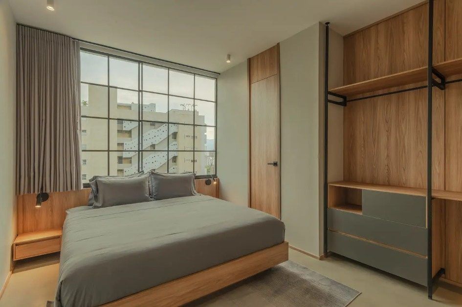 Habitación con ventanal y closet de madera en Ático, Medellín