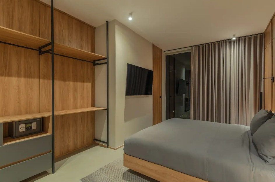 Habitación con paneles de madera y TV en el penthouse Ático, Medellín