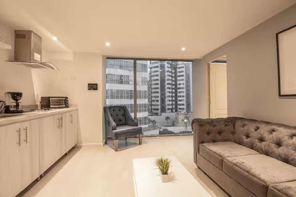 Sofá y cocineta con vista a la ciudad en Boca Grande Loft, Cartagena