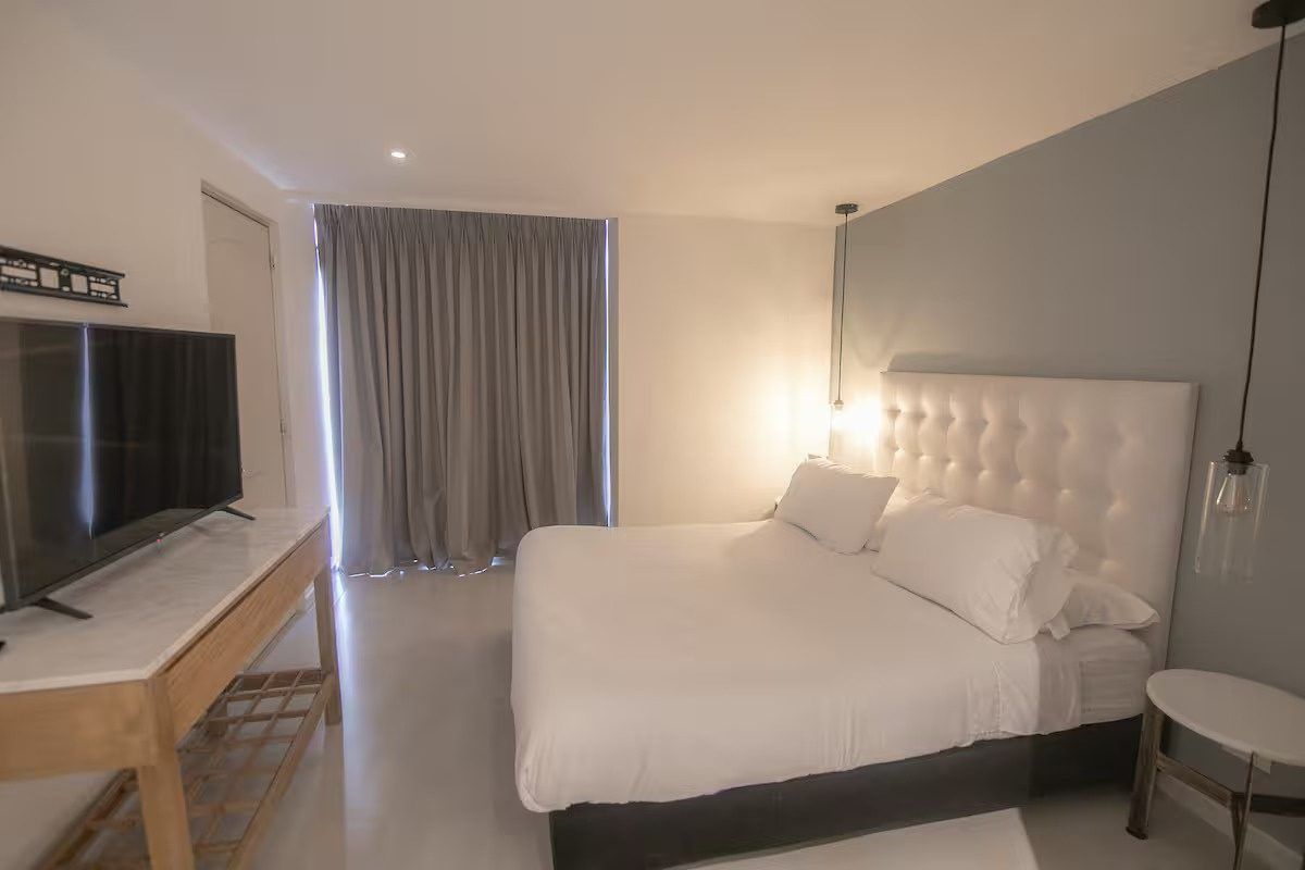 Habitación con cabecero capitoné y luz suave en Boca Grande Loft, Cartagena
