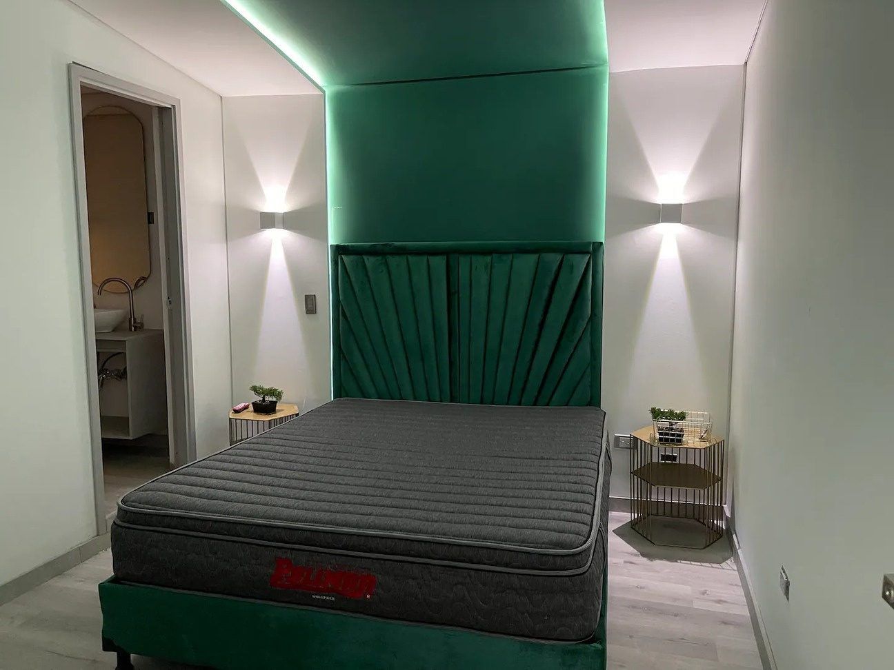 Habitación con pared de acento verde en Emerald, Medellín