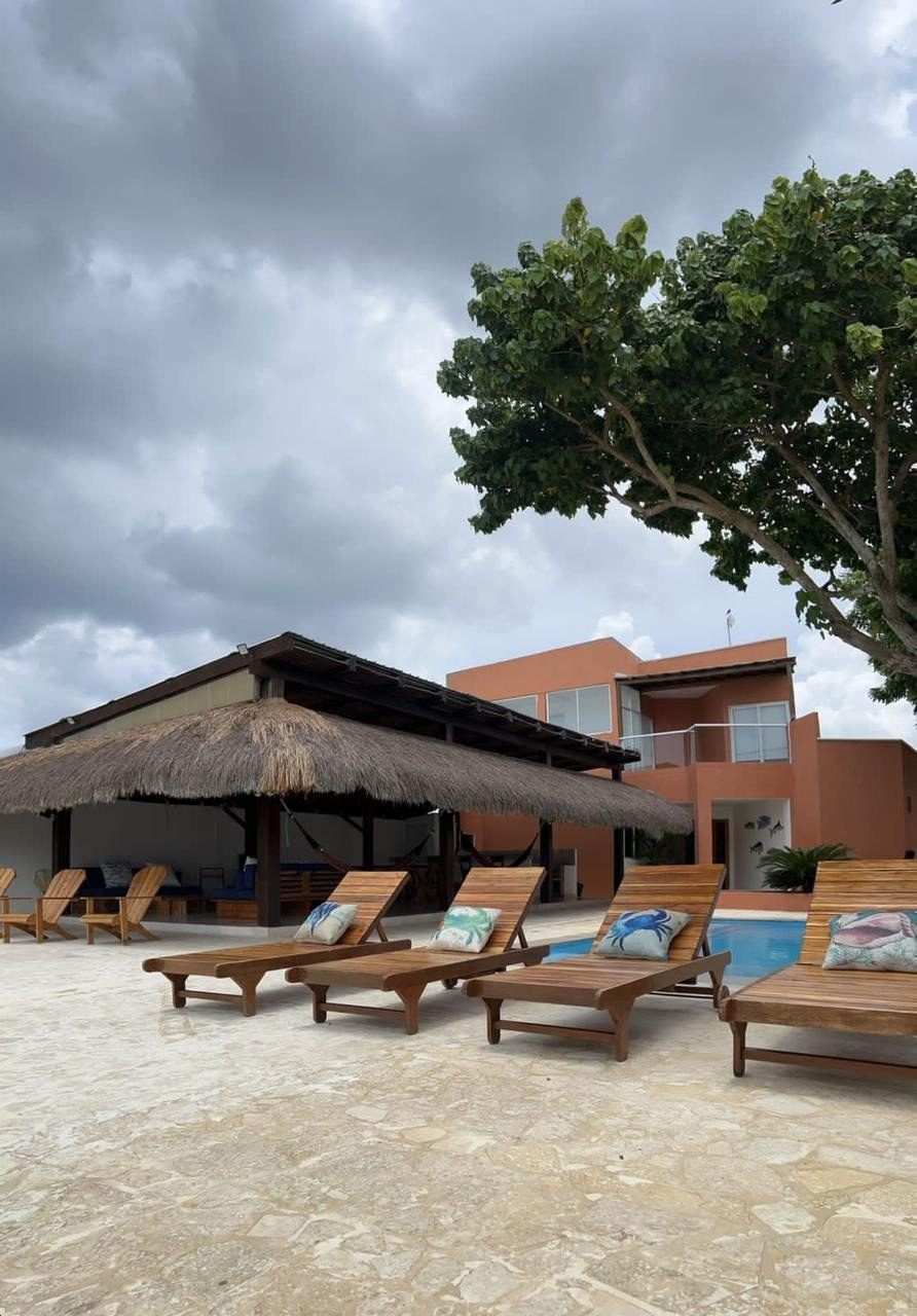 Sun loungers and thatched kiosk by the pool at House Playa, Cartagena