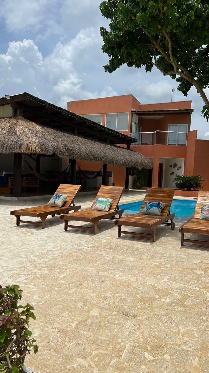 Pool deck with sun loungers and villa at House Playa, Cartagena