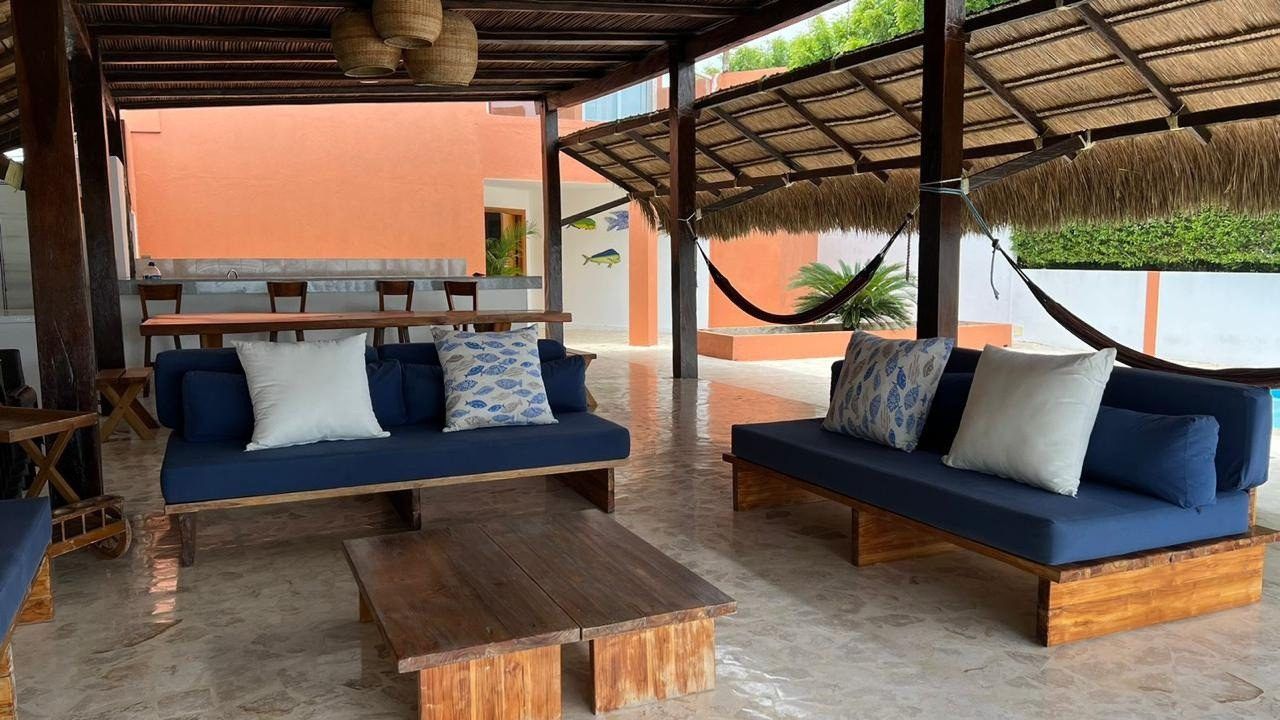 Shaded kiosk lounge with blue sofas and hammock at House Playa, Cartagena