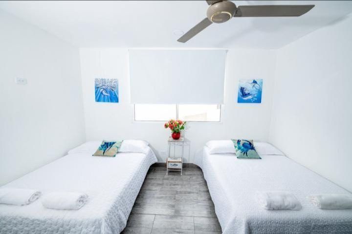 Bright bedroom with twin beds at House Playa, Cartagena
