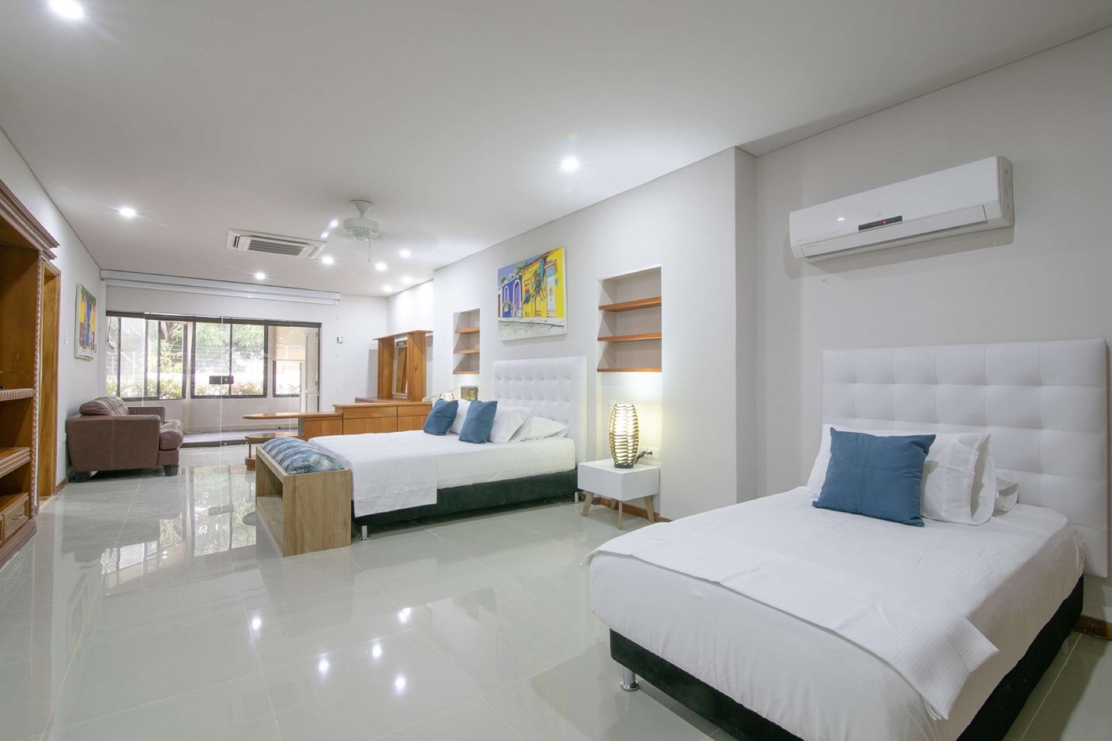 Bedroom with two beds and sitting area at Mar House, Cartagena