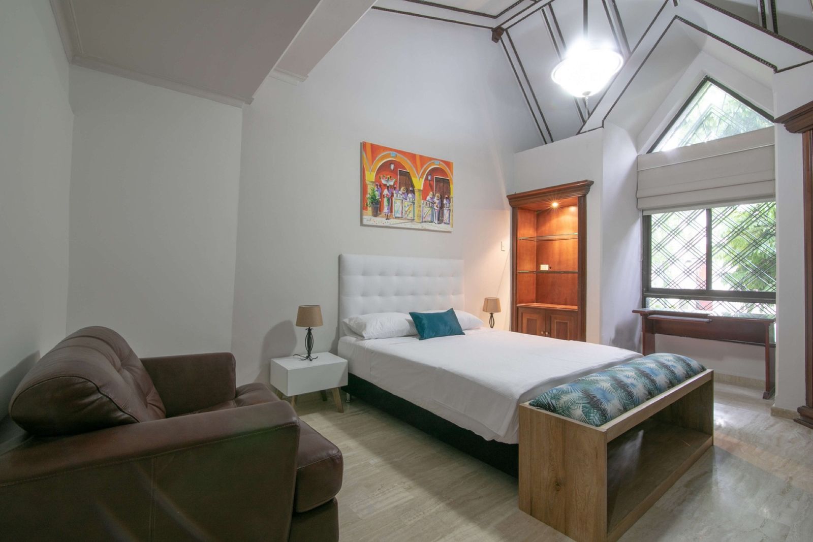 Bedroom with vaulted ceiling and armchair at Mar House, Cartagena