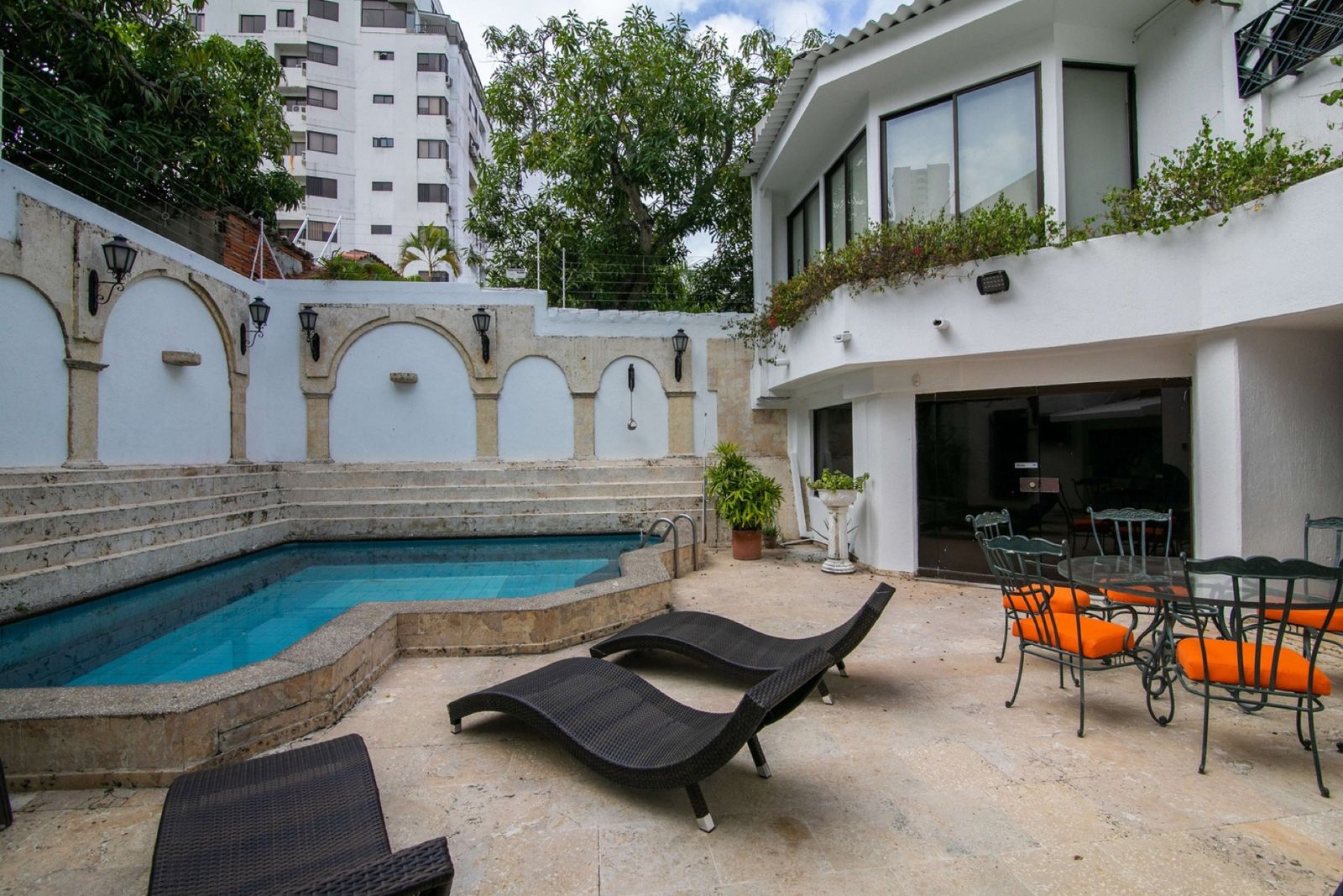 Patio with arched stone walls around the pool at Mar House, Bocagrande