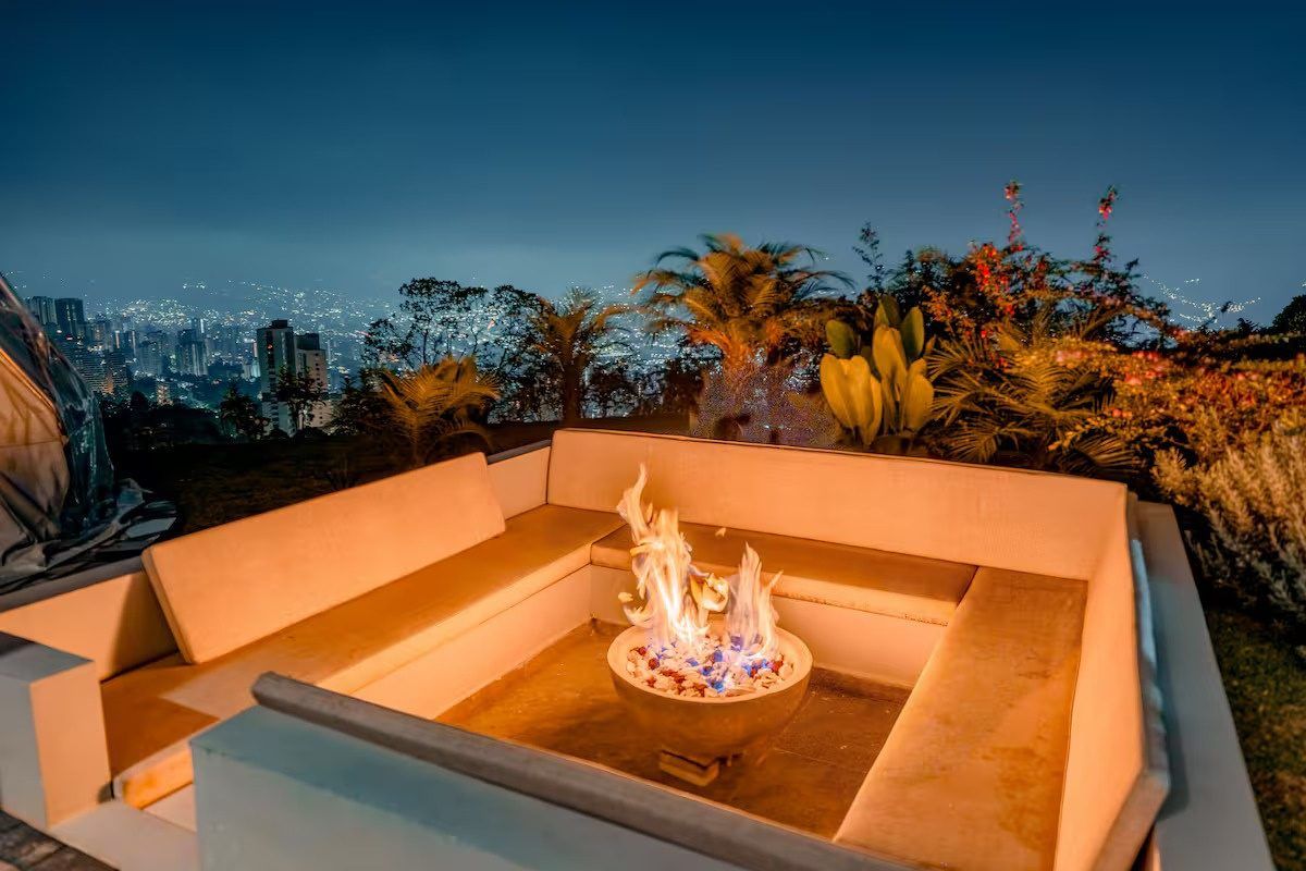 Terraza con fogata de noche y vista a Medellín, Palmas Royal View