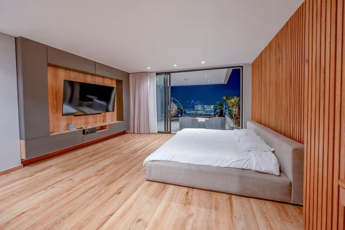 Habitación principal con paneles de madera y acceso al balcón, Palmas Royal View, Medellín