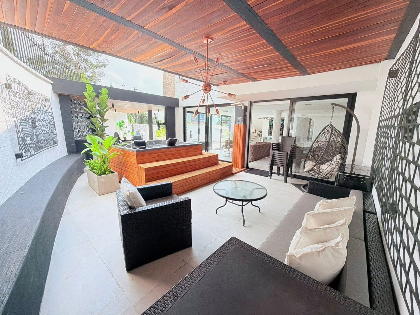 Covered terrace with lounge and hanging chair at Pool House, Medellin