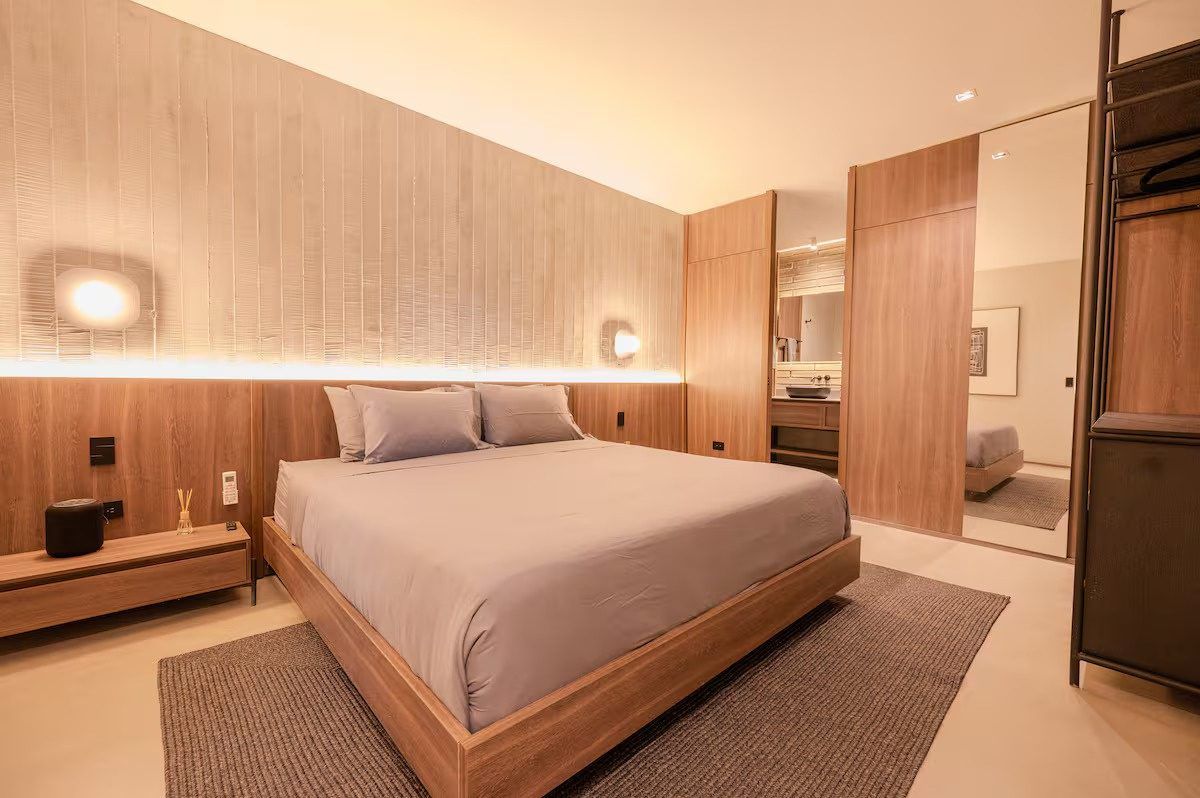Bedroom with wood headboard and warm lighting at Provenza 3, Medellin