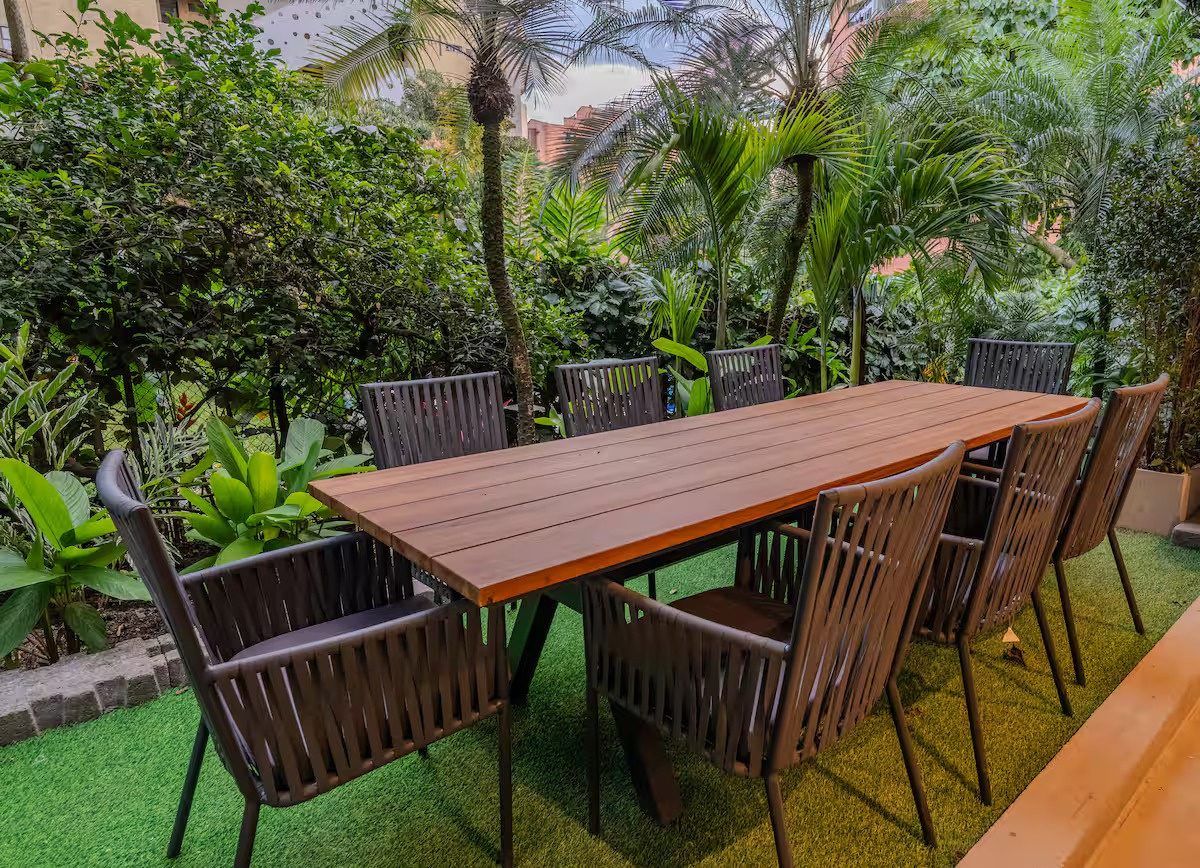 Teak dining table surrounded by tropical garden at Provenza 3, Medellin