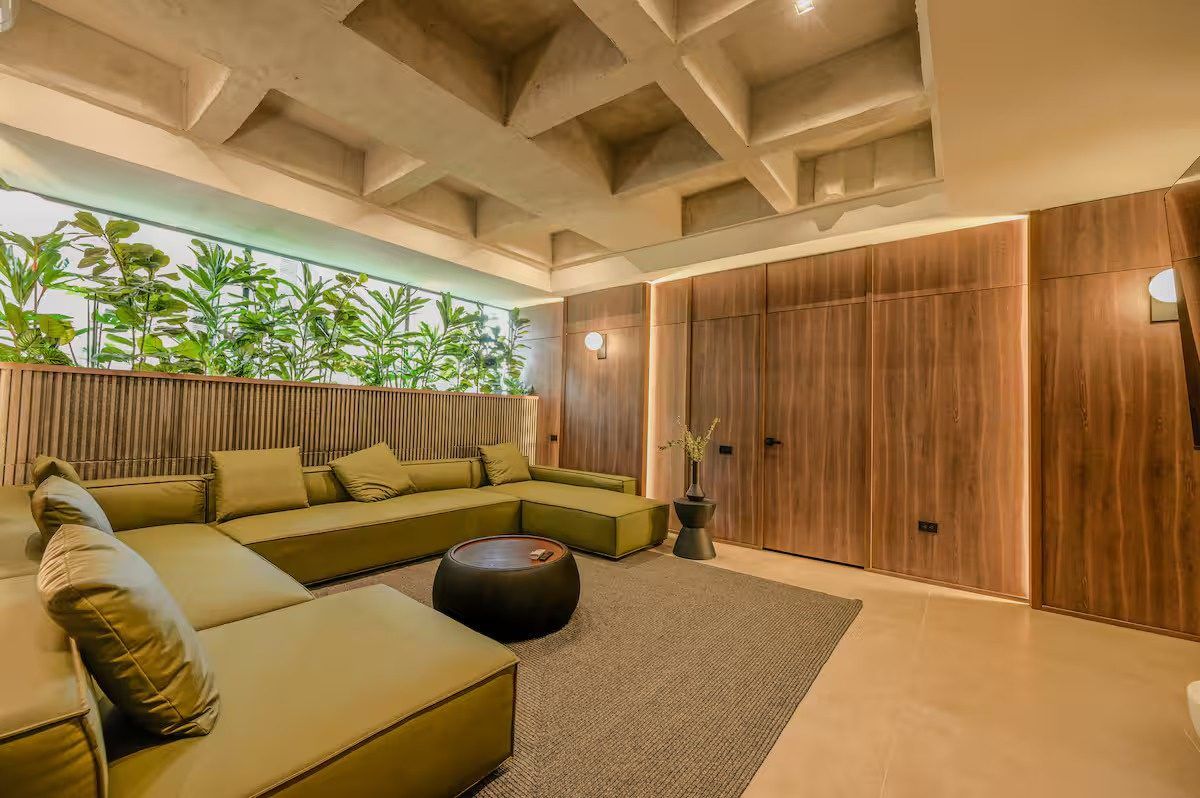 Living room with olive sofa and wood paneling at Provenza 3, Medellin