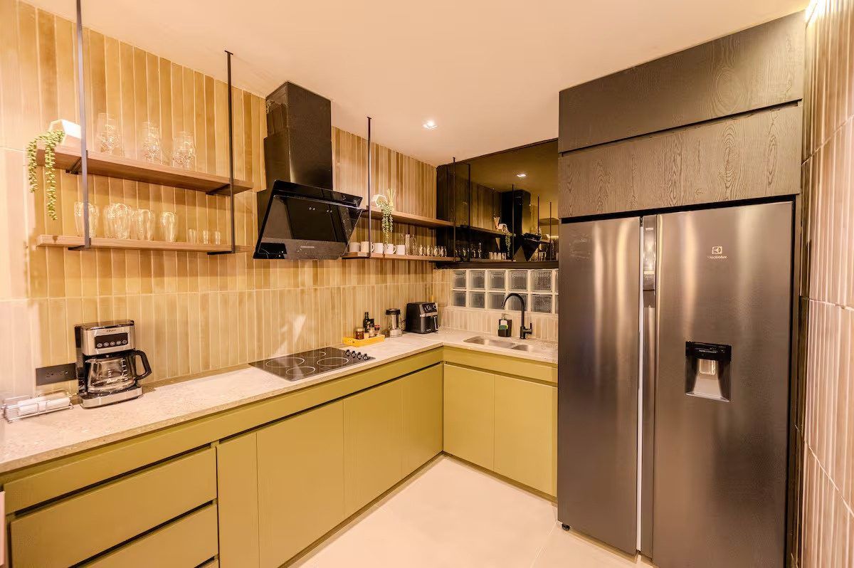 Kitchen with stainless fridge and olive cabinets at Provenza 3, Medellin