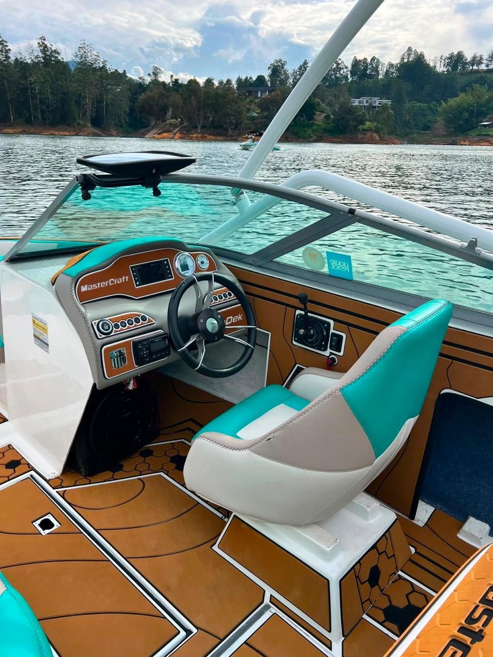 Timón y sillas turquesa del bote de wakeboard Mastercraft en el embalse de Guatapé
