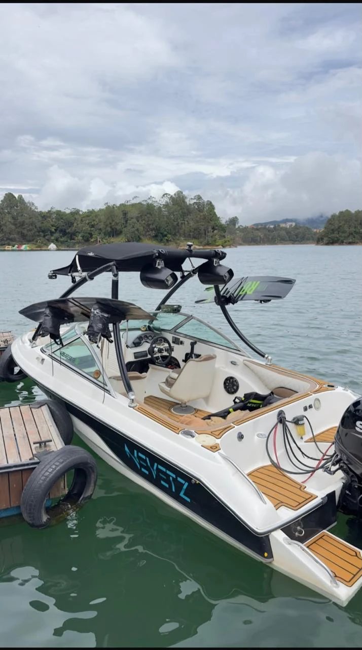 Bote de wakeboard White Nevetz en el muelle de Guatapé con torre y tablas