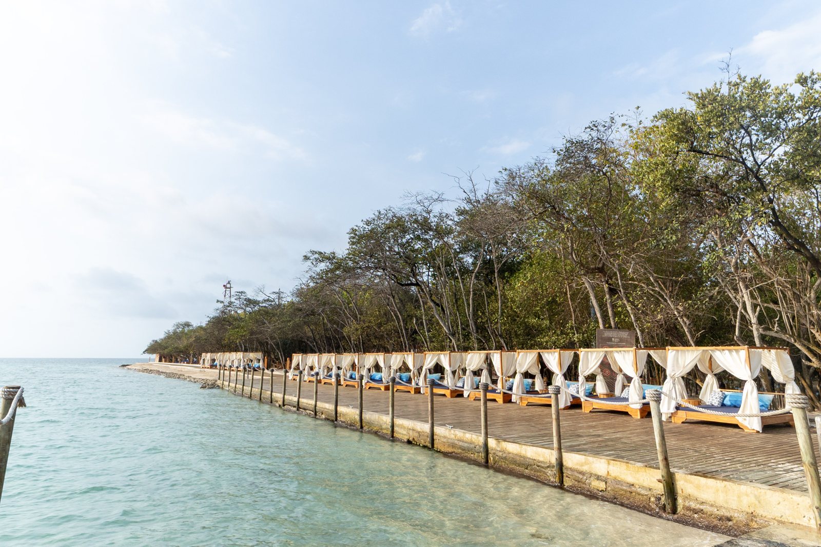 Row of shaded beach beds along the shore at Corona Island, Rosario Islands, Cartagena