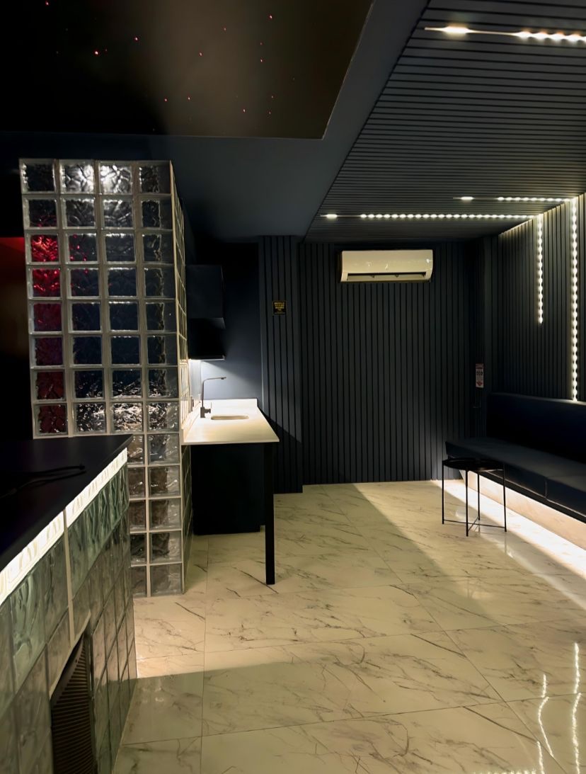 Blue Room in Medellín: bar counter with sink, glass-block column and lounge banquette