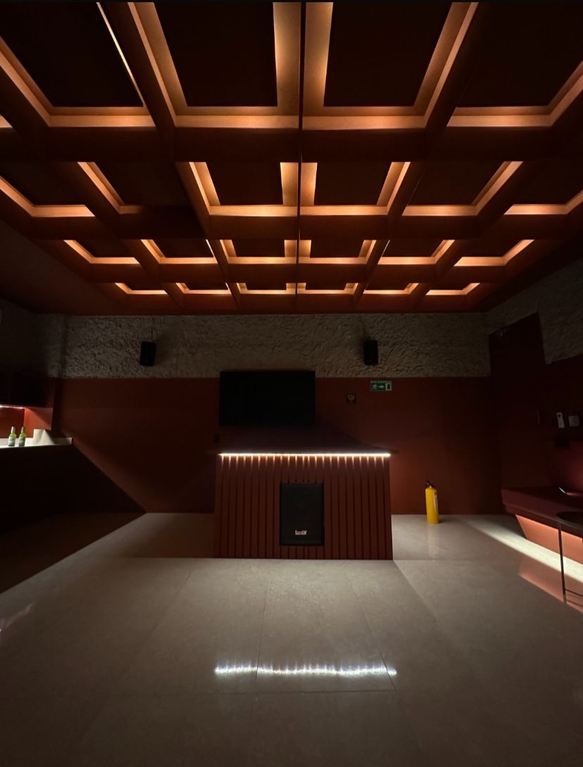 Red Room in Medellín: slatted DJ booth with professional speaker under the warm coffered ceiling